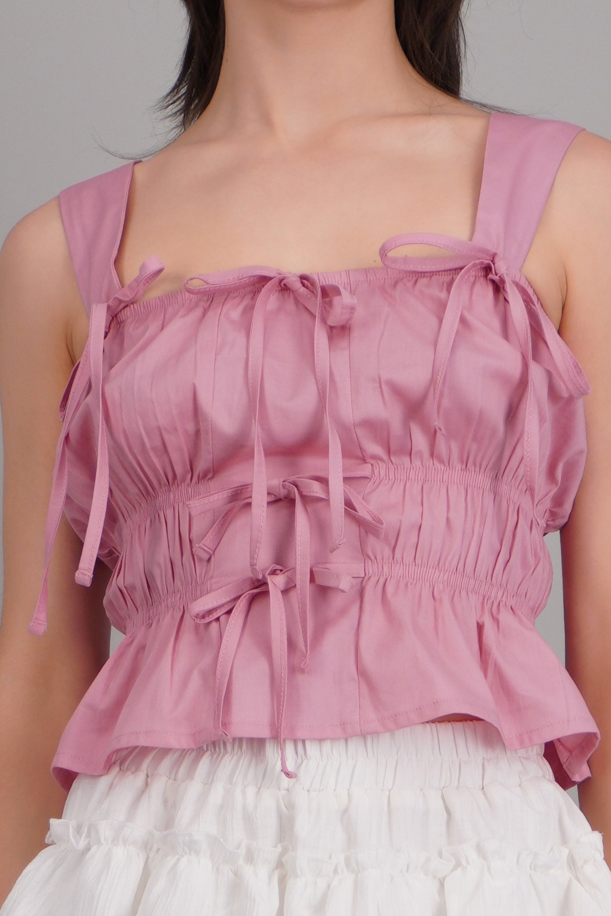 Top sin mangas detalle moños ROSA PASTEL